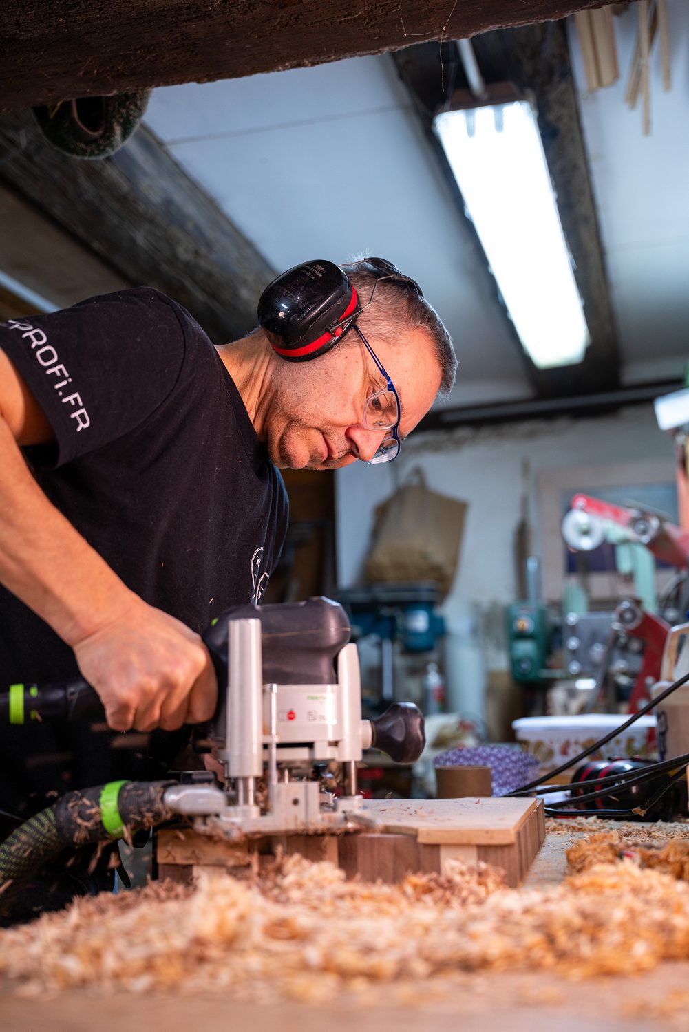 Homme utilisant une defonceuse electrique pour travailler le bois.