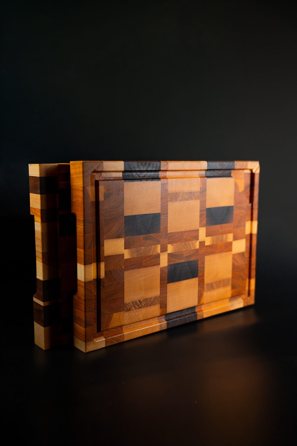 Deux planches a decouper en bois a motifs geometriques.